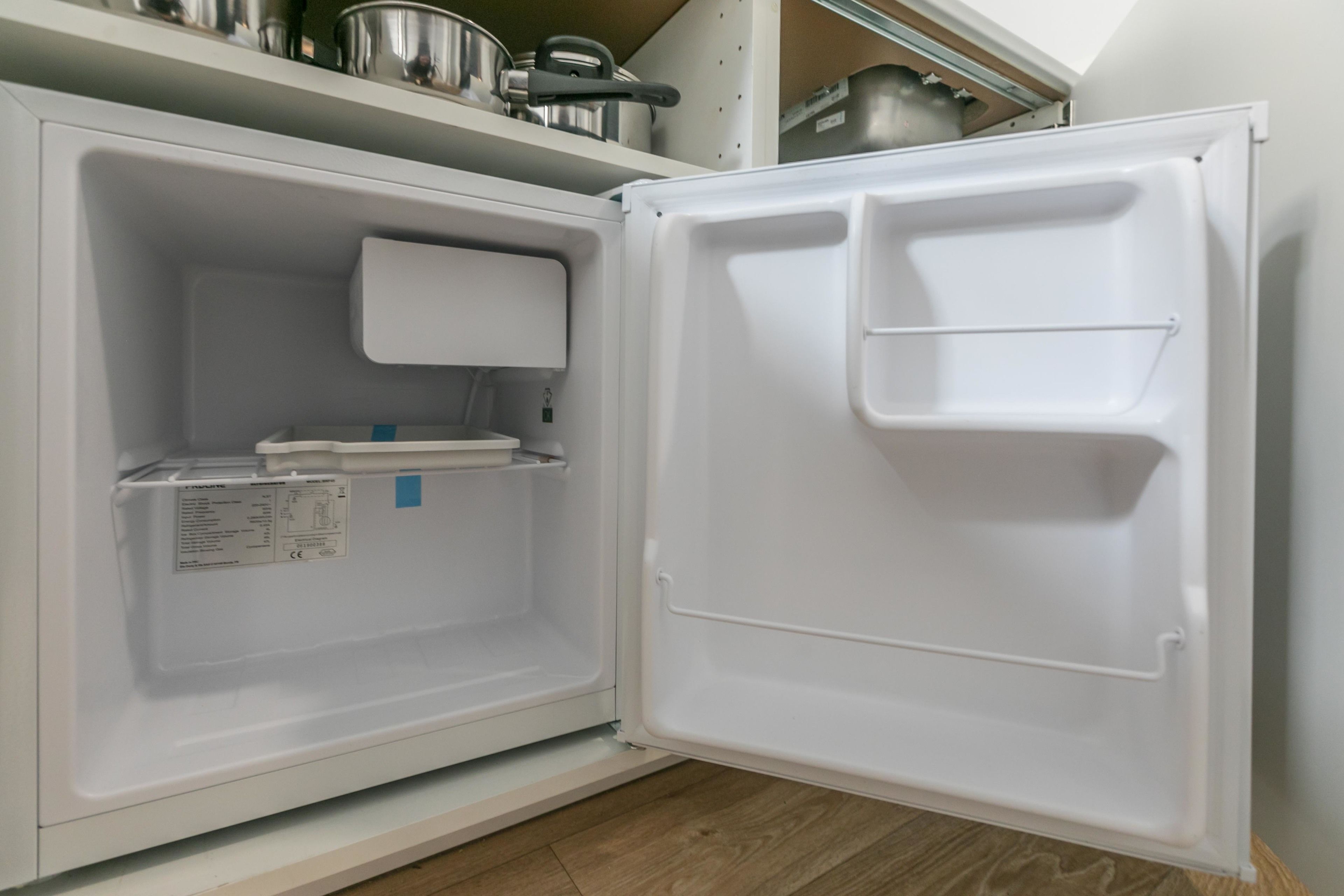 An open refrigerator with a freezer compartment on the left and a main compartment on the right.