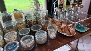 Um buffet de café da manhã com diversos alimentos e uma estação de café.
