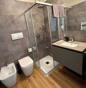 Klassieke tweepersoonskamer | Badkamer | Een douche, een haardroger, een bidet, handdoeken