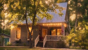 Ein Holzhaus mit Veranda, Treppe und einer US-amerikanischen Flagge.