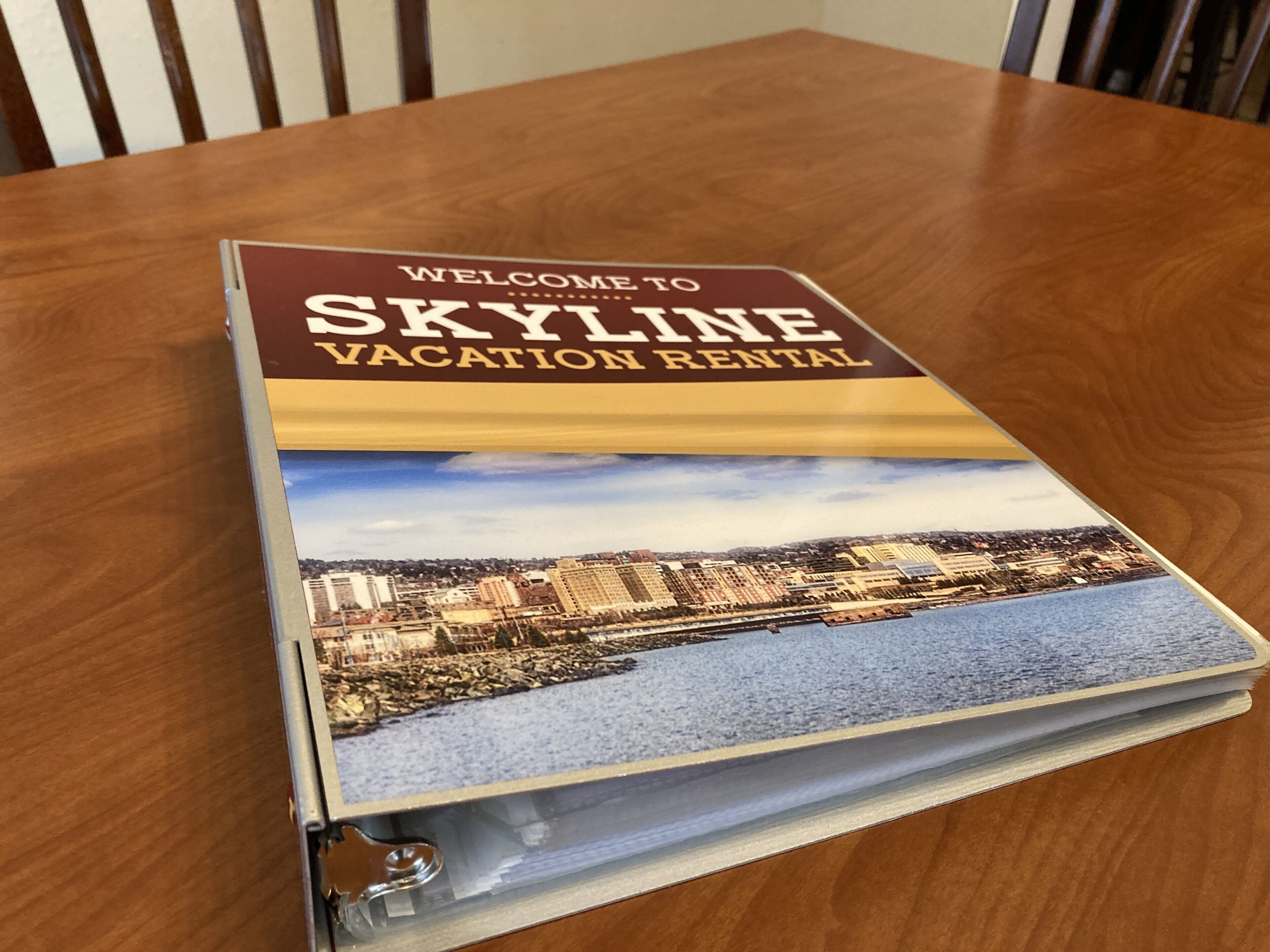 A brochure titled "Welcome to Skyline Vacation Rental" with a cityscape image on the cover.
