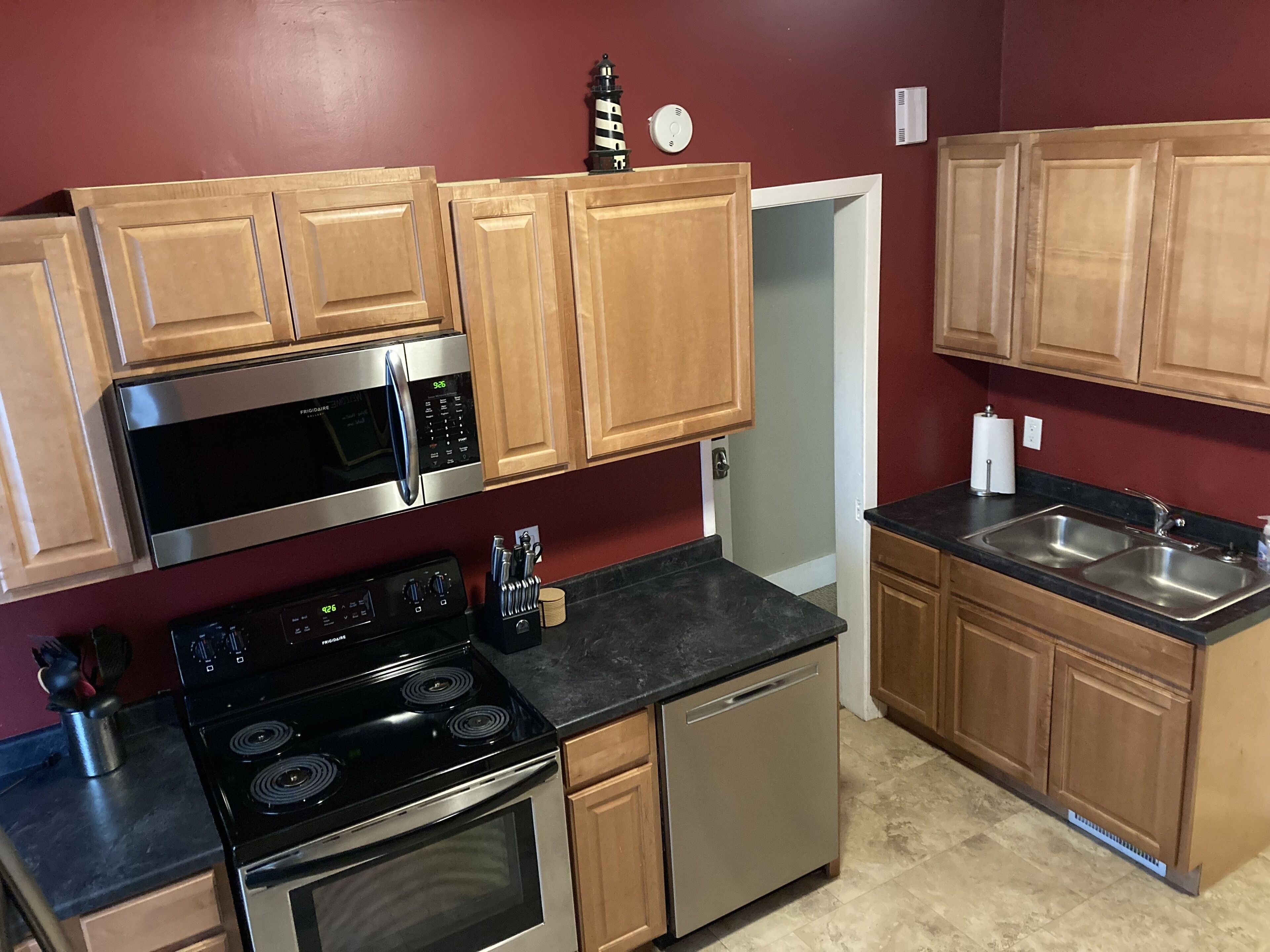 A kitchen with wooden cabinets, a stainless steel microwave, a stove, and a dishwasher.