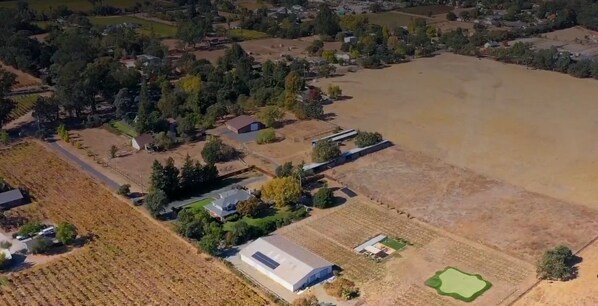 Vista aérea de una zona rural con campos, casas dispersas y un amplio espacio abierto.