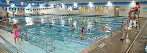 An indoor swimming pool with multiple lanes, a lifeguard chair, and a 'NO DIVING' sign.