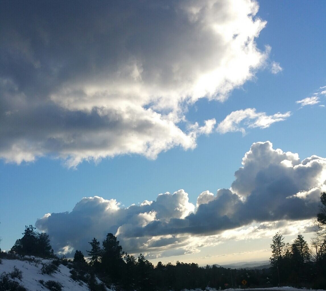 Un paisaje montañoso con cielo despejado y algunas nubes dispersas.