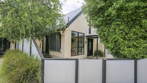 A modern house with a large glass window, a door, and a small porch area. - ALLAMBIE COTTAGES - VILLA 1: Bright (Bright)