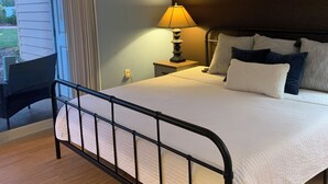 A bedroom with a bed, bedside table, lamp, and a wall-mounted fish decoration.
