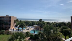 A resort with a pool, beach, and ocean view.