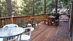A wooden deck with picnic tables and chairs, surrounded by trees. - Pinecrestarearentals #8 Getaway Fall/labor day 3rd night free just Book 2nights. (Cold Springs)