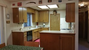 A compact kitchen with wooden cabinets, a built-in dishwasher, a coffee maker, and a stove. - Pinecrestarearentals #8 Getaway Fall/labor day 3rd night free just Book 2nights. (Cold Springs)