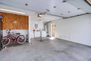 Un garaje con pared de madera, lavadora y bicicleta.