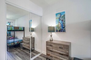 A bedroom with a bunk bed, a wooden dresser, a mirror, and a painting on the wall. - New-A/C! Between Beach and Bay, garage/bikes/pets! (San Diego)