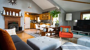 Un salon moderne avec une cheminée, un coin repas et une cuisine.