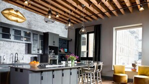 Una cocina moderna con una isla central, taburetes de bar y un ventanal que proporciona luz natural.