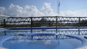 A swimming pool with a metal fence and a clear sky. - Charming Mexican Style Condo with a fantastic location (Playa del Carmen)