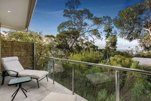A balcony with a glass railing, a lounge chair, and a table. - Horizons - A Luxurious Retreat (Lorne)