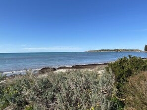 A coastal landscape with a clear view of the sea, sandy beach, and rocky outcrops. - Southern Escape - A Family Friendly Home 3 minute walk to  the Beach  (VICTOR HARBOR)