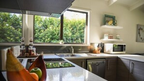 Una cocina moderna con un ventanal grande, un microondas y un lavamanos.