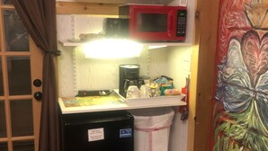 A compact kitchen with a refrigerator, microwave, and coffee maker.