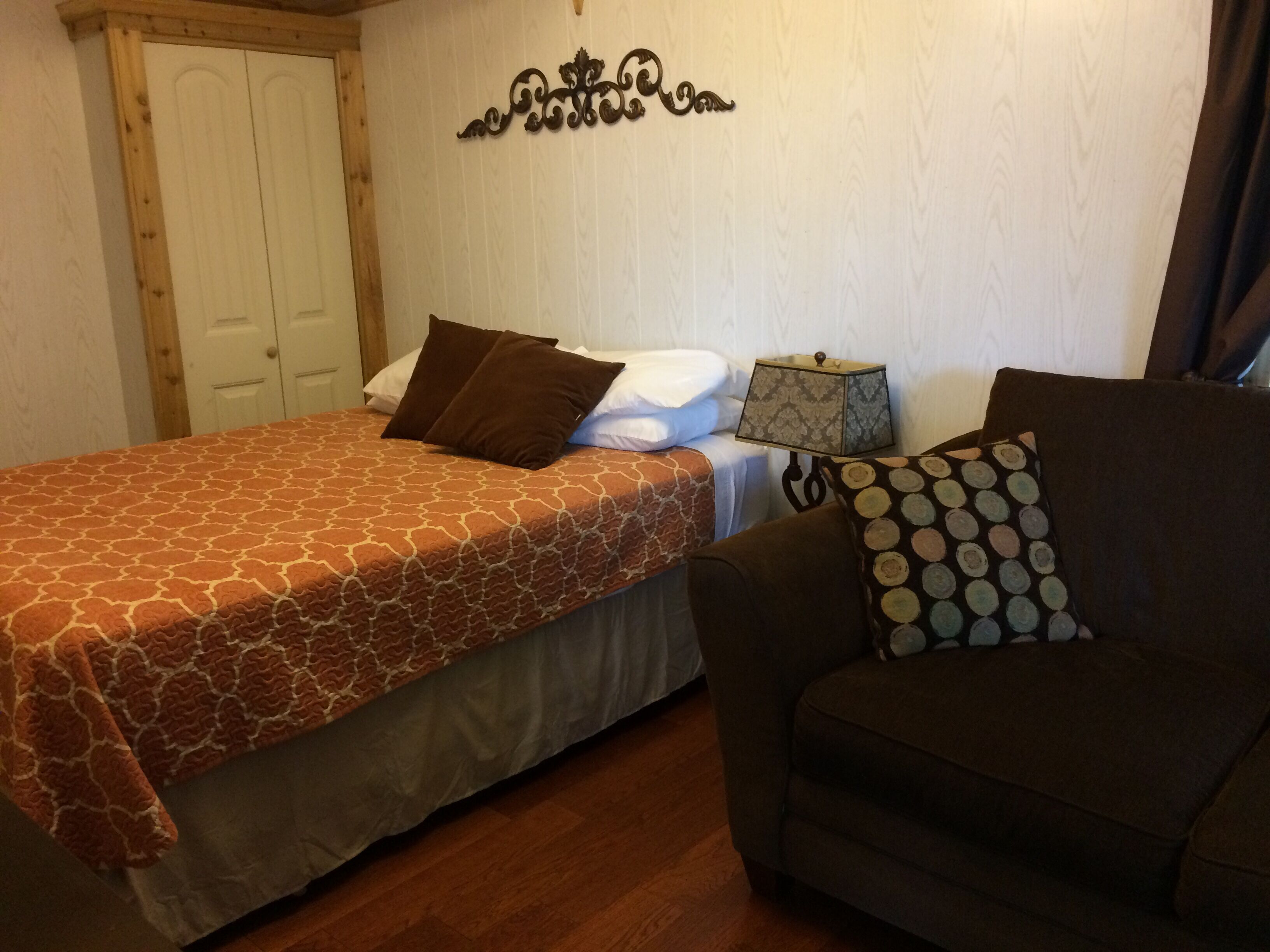 Une chambre à coucher avec un lit, une table de chevet, une lampe et un canapé.