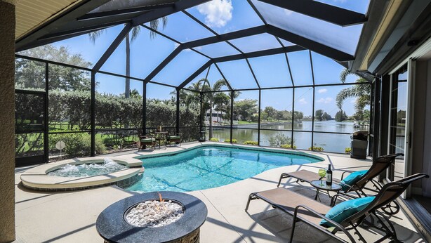 Zona de piscina con jacuzzi, sillas de descanso y vista al lago.