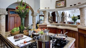 A spacious kitchen with granite countertops, a large island, and a view of the dining area. - Beachfront Delfin Estate with Pool (Sleeps 41) (Mazatlán)