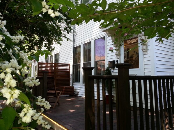 A wooden deck with a bench, a mailbox, and a house with white siding. - Maria's JP Rental - Boston Duplex in Popular Jamaica Plain "JP" area (Boston)
