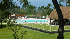 A pool area with a clear view of the pool, surrounded by lounge chairs and a covered seating area.