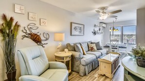 Un salon comprenant un canapé, un fauteuil et une petite table agrémentée d’objets décoratifs.