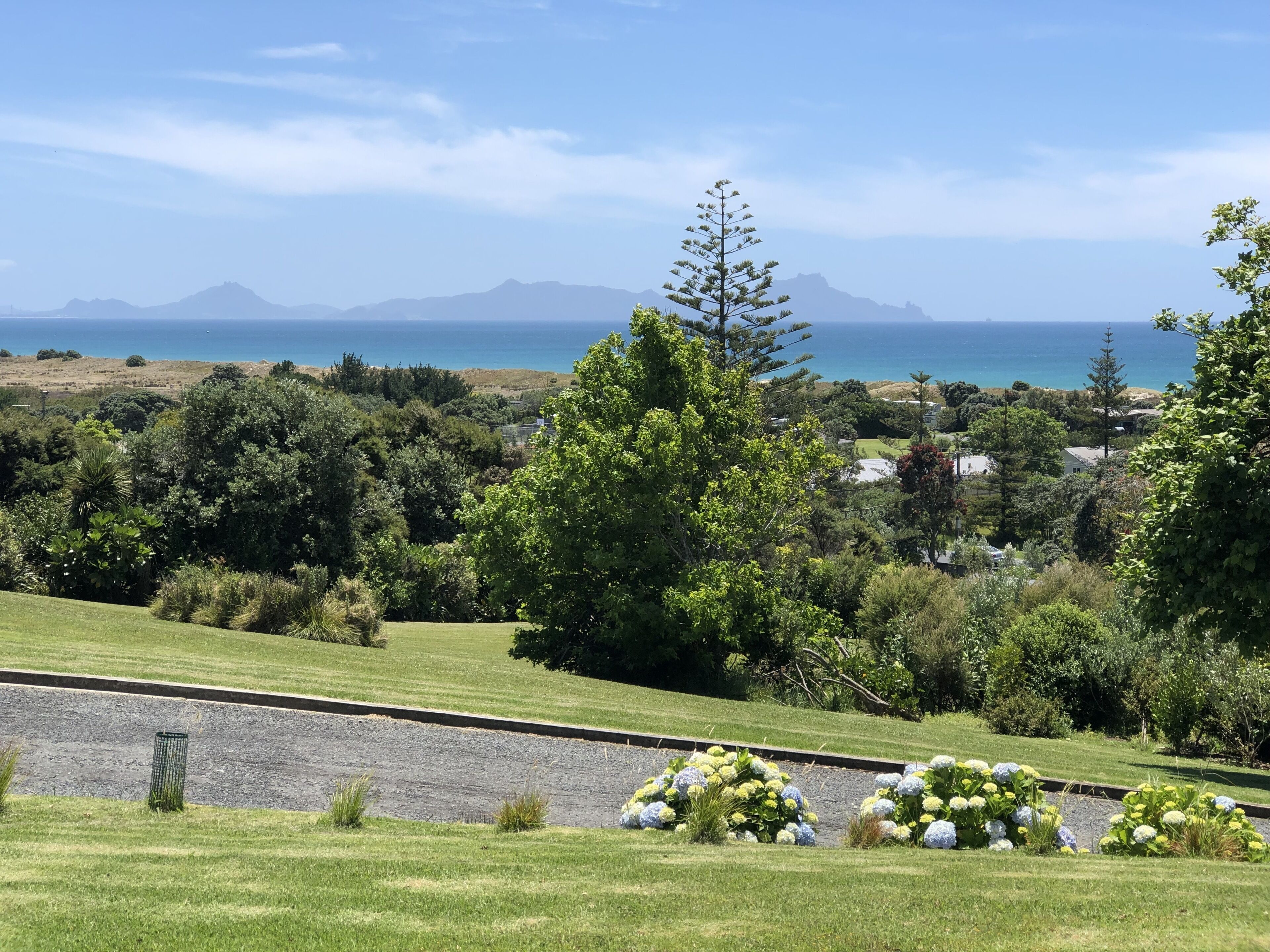 Un jardin aménagé offrant une vue sur la mer et les montagnes.