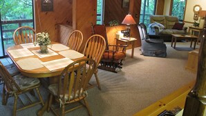Un intérieur en bois comprenant une table à manger, des chaises, un canapé et une lampe.
