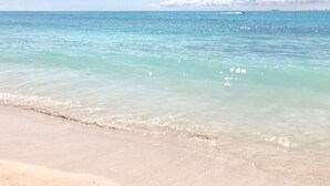 A beach with clear turquoise water and a sandy shore.
