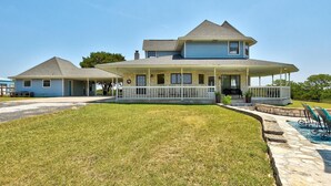 A two-story house with a covered porch and a swimming pool.
