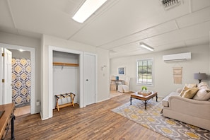 A spacious living room with a sofa, coffee table, and a patterned rug. - Prosit Ranch - 300 Acre Private Ranch w/360 Degree Views & Wrap-Around Porch (Wimberley)