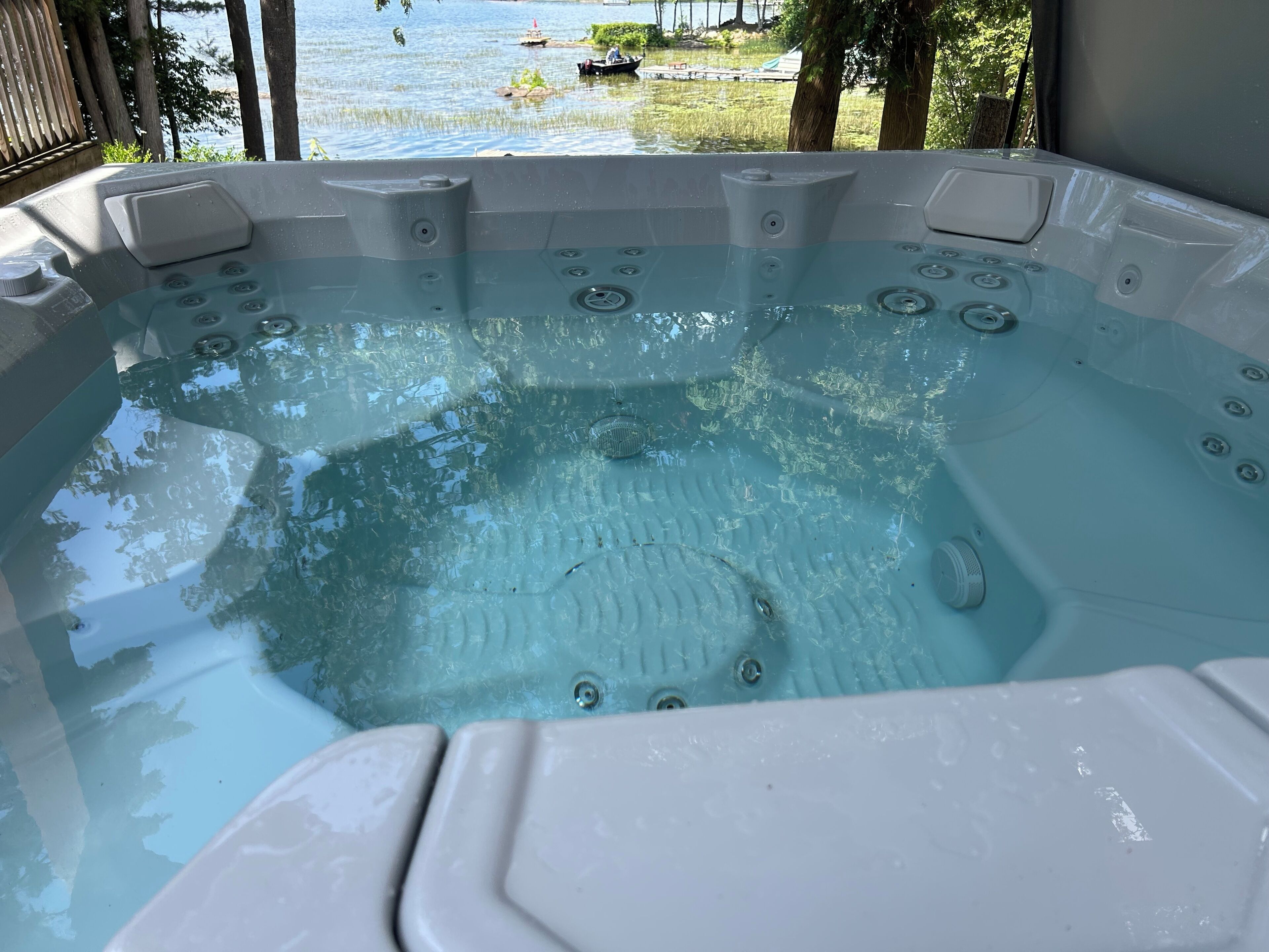 Un bain à remous avec vue sur un lac et des bateaux.