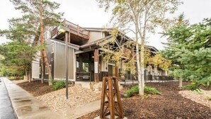 A modern building with a wooden deck and a covered outdoor area. - Centrally Located Studio Condo, minutes from Main St and Skiing! (Park City)