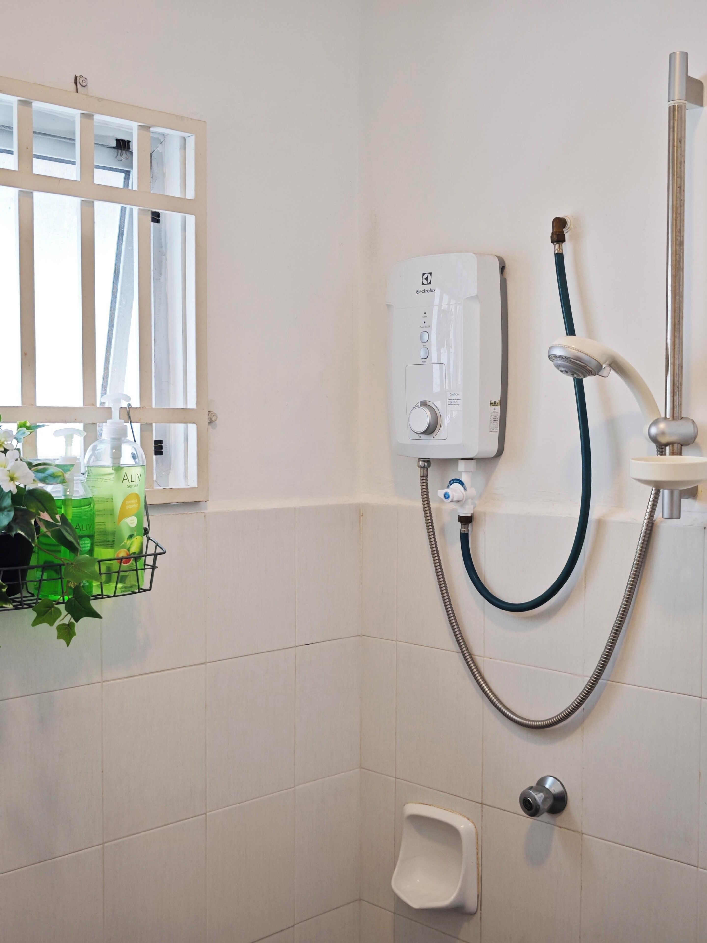 Een badkamer met een douche, toilet en een raam met uitzicht.