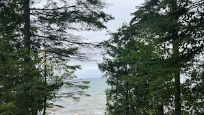 A forested path leading to a beach with a view of the ocean. - A beautiful log cabin home on Lake Huron, amazing lake views, hot tub, game room (Cheboygan)