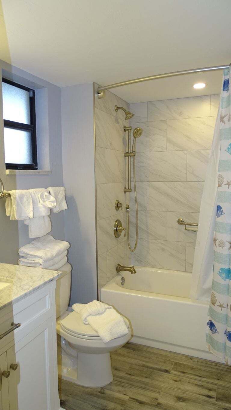 A bathroom with a shower, toilet, and sink.