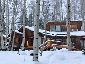 Una cabaña de madera rodeada de árboles cubiertos de nieve.