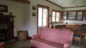 Una sala de estar con un sofá a rayas, una mesa de centro de madera y una chimenea.