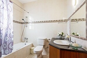 A bathroom with a bathtub, toilet, and sink.