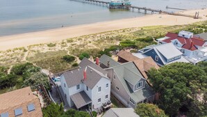 Een kustgebied met huizen, een steiger en een strand.