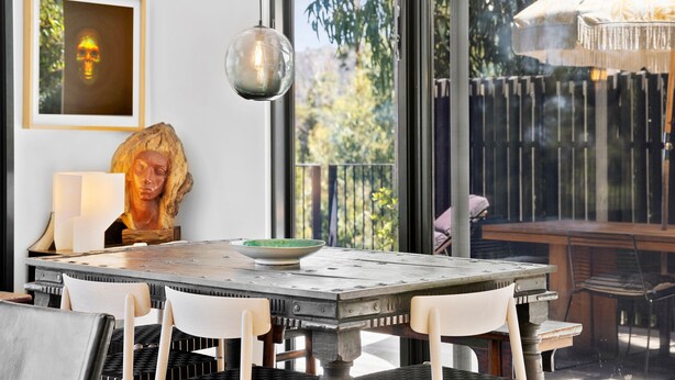 A dining area with a table, chairs, a hanging light fixture, and a view of the outdoors. - Tucker House (Wye River)