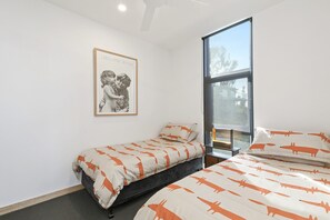 Ein Schlafzimmer mit einem Einzelbett, einem Fenster und einem Bild an der Wand.
