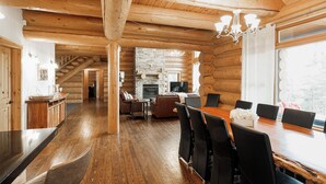 Ein großzügiges Blockhaus mit Essbereich, Küche und Wohnzimmer.