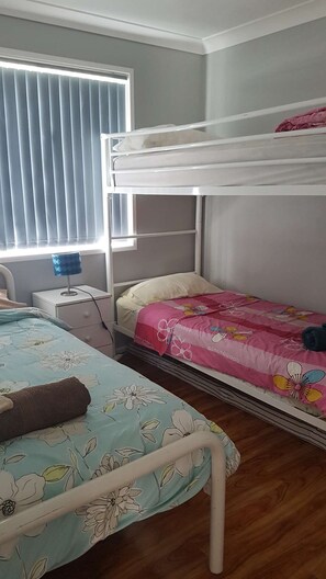 2 dormitorios y tabla de planchar con plancha