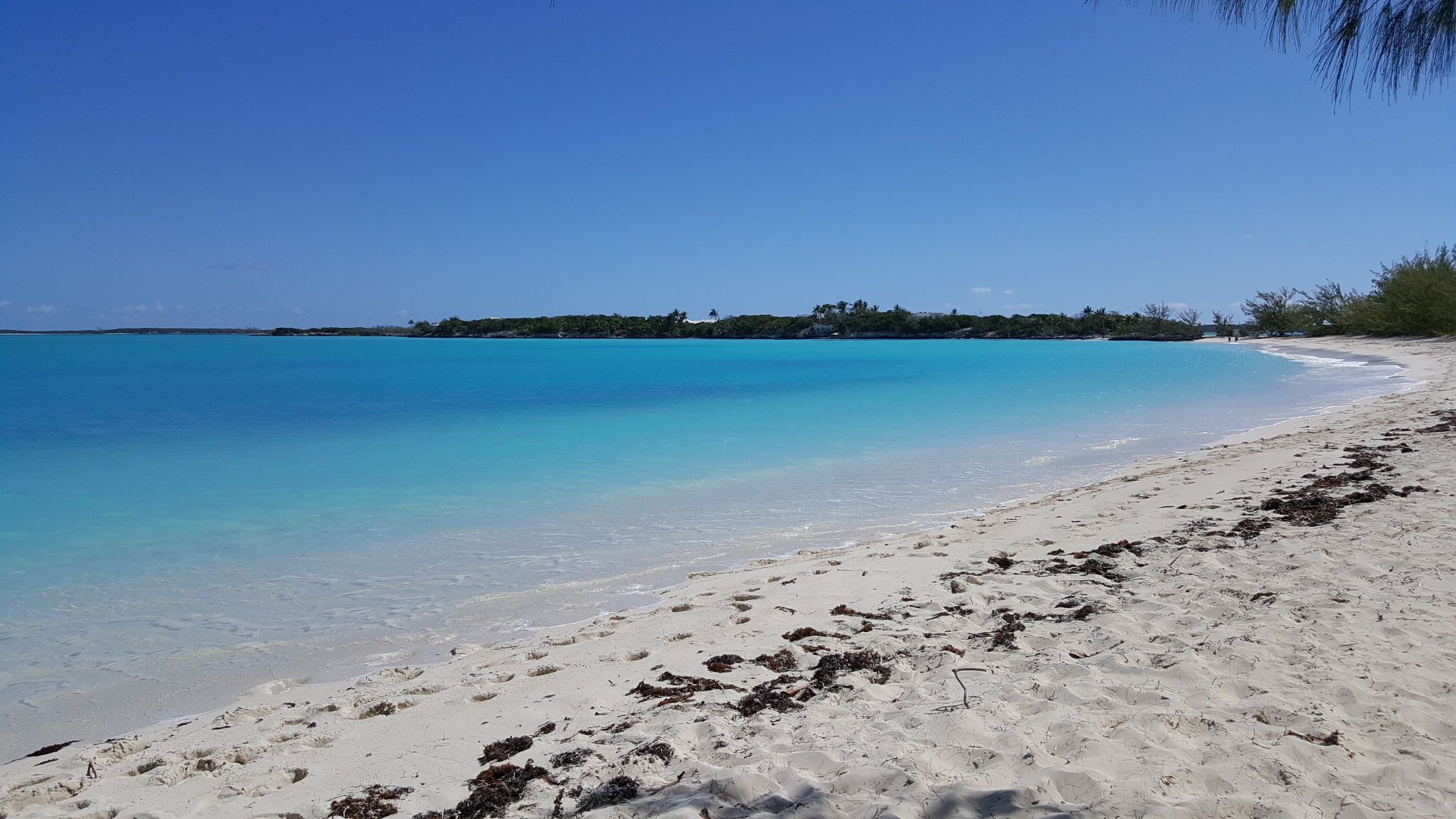 Una playa con agua turquesa cristalina y arena blanca.
