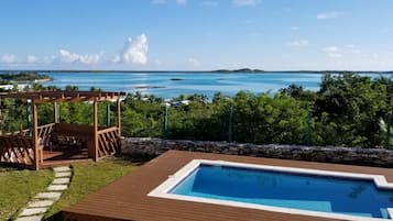 Een buitenzwembad, ligstoelen bij het zwembad