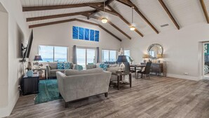 A spacious living room with a high ceiling, large windows, and a view of the ocean. - The nicest beach house in Great Harbour,   Guaranteed!   Enjoy🏝 (Great Harbour Cay, Bahamas (GHC))